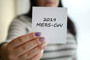 MERS-CoV Novel Corona virus inscription on paper in female hand. Middle East Respiratory Syndrome. Chinese infection photo