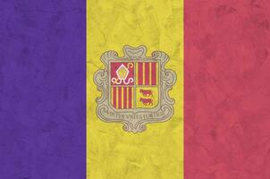 Andorra flag depicted in bright paint colors on old relief plastering wall. Textured banner on rough background photo