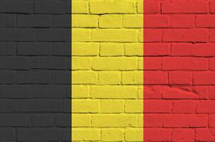 Belgium flag depicted in paint colors on old brick wall. Textured banner on big brick wall masonry background photo