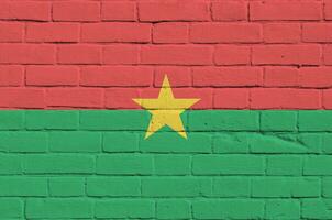 Burkina Faso flag depicted in paint colors on old brick wall. Textured banner on big brick wall masonry background photo