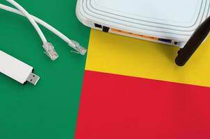 Benin flag depicted on table with internet rj45 cable, wireless usb wifi adapter and router. Internet connection concept photo