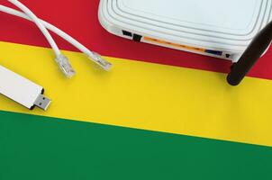 Bolivia flag depicted on table with internet rj45 cable, wireless usb wifi adapter and router. Internet connection concept photo