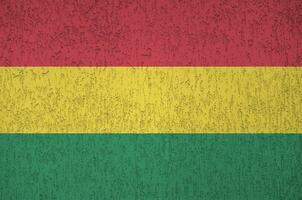 Bolivia flag depicted in bright paint colors on old relief plastering wall. Textured banner on rough background photo