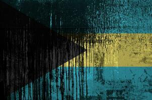 Bahamas flag depicted in paint colors on old and dirty oil barrel wall closeup. Textured banner on rough background photo