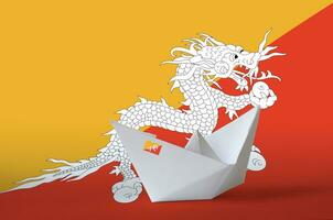 Bhutan flag depicted on paper origami ship closeup. Handmade arts concept photo
