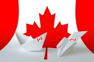 Canada flag depicted on paper origami airplane and boat. Handmade arts concept photo