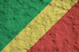 Congo flag depicted in bright paint colors on old relief plastering wall. Textured banner on rough background photo