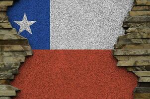 Chile flag depicted in paint colors on old stone wall closeup. Textured banner on rock wall background photo