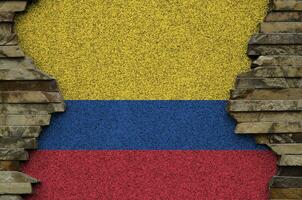 Colombia flag depicted in paint colors on old stone wall closeup. Textured banner on rock wall background photo