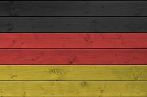 Alemania bandera representado en brillante pintar colores en antiguo de madera pared. texturizado bandera en áspero antecedentes foto