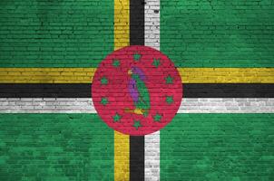 Dominica flag depicted in paint colors on old brick wall. Textured banner on big brick wall masonry background photo