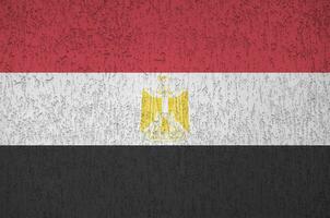 Egypt flag depicted in bright paint colors on old relief plastering wall. Textured banner on rough background photo