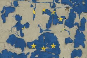 European union flag depicted in paint colors on old obsolete messy concrete wall closeup. Textured banner on rough background photo