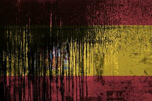 Spain flag depicted in paint colors on old and dirty oil barrel wall closeup. Textured banner on rough background photo