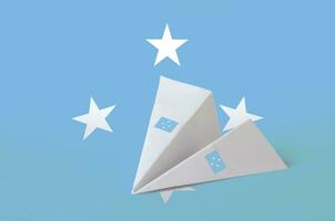 Micronesia flag depicted on paper origami airplane. Handmade arts concept photo