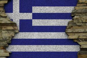 Greece flag depicted in paint colors on old stone wall closeup. Textured banner on rock wall background photo