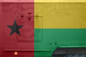 Guinea Bissau flag depicted on side part of military armored truck closeup. Army forces conceptual background photo