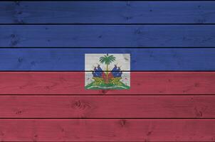 Haiti flag depicted in bright paint colors on old wooden wall. Textured banner on rough background photo