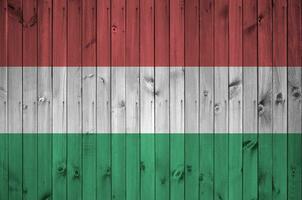 Hungría bandera representado en brillante pintar colores en antiguo de madera pared. texturizado bandera en áspero antecedentes foto