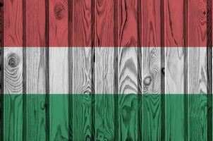 Hungary flag depicted in bright paint colors on old wooden wall. Textured banner on rough background photo