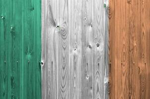 Ireland flag depicted in bright paint colors on old wooden wall. Textured banner on rough background photo