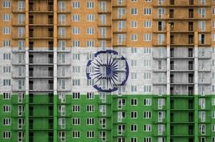 India flag depicted in paint colors on multi-storey residental building under construction. Textured banner on brick wall background photo