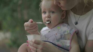 Mother feeding little daughter outside video