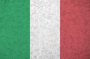 Italy flag depicted in bright paint colors on old relief plastering wall. Textured banner on rough background photo