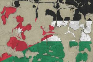 Jordan flag depicted in paint colors on old obsolete messy concrete wall closeup. Textured banner on rough background photo