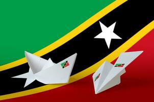 Santo kitts y nevis bandera representado en papel origami avión y bote. hecho a mano letras concepto foto