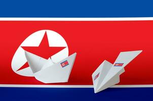 North Korea flag depicted on paper origami airplane and boat. Handmade arts concept photo