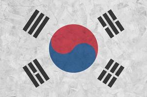 South Korea flag depicted in bright paint colors on old relief plastering wall. Textured banner on rough background photo