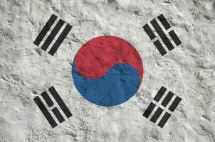 South Korea flag depicted in bright paint colors on old relief plastering wall. Textured banner on rough background photo