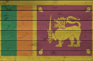 sri lanka bandera representado en brillante pintar colores en antiguo de madera pared. texturizado bandera en áspero antecedentes foto
