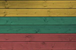 Lithuania flag depicted in bright paint colors on old wooden wall. Textured banner on rough background photo