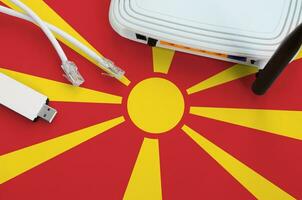 Macedonia flag depicted on table with internet rj45 cable, wireless usb wifi adapter and router. Internet connection concept photo