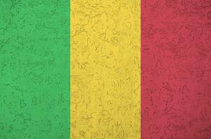 Mali flag depicted in bright paint colors on old relief plastering wall. Textured banner on rough background photo