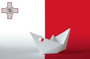 Malta flag depicted on paper origami ship closeup. Handmade arts concept photo