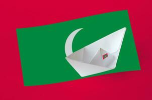 Maldives flag depicted on paper origami ship closeup. Handmade arts concept photo