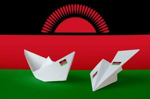 Malawi flag depicted on paper origami airplane and boat. Handmade arts concept photo