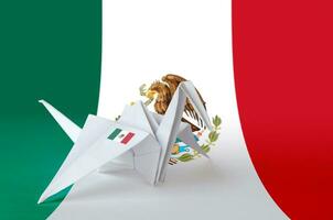 Mexico flag depicted on paper origami crane wing. Handmade arts concept photo