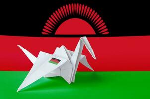 Malawi flag depicted on paper origami crane wing. Handmade arts concept photo