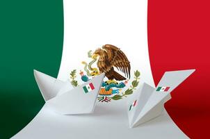 Mexico flag depicted on paper origami airplane and boat. Handmade arts concept photo