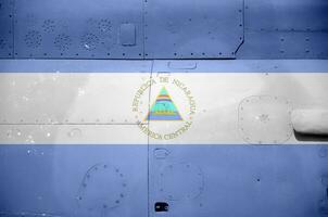 Nicaragua flag depicted on side part of military armored helicopter closeup. Army forces aircraft conceptual background photo