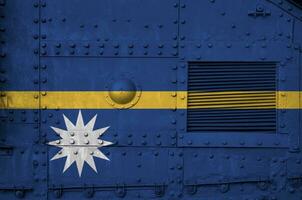 Nauru flag depicted on side part of military armored tank closeup. Army forces conceptual background photo