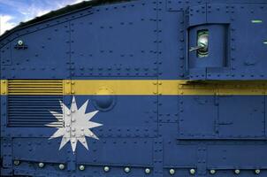 Nauru flag depicted on side part of military armored tank closeup. Army forces conceptual background photo