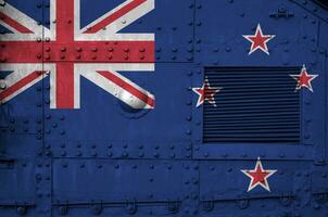 New Zealand flag depicted on side part of military armored tank closeup. Army forces conceptual background photo