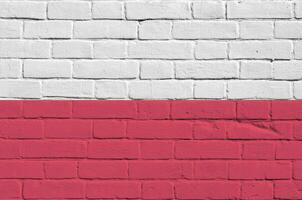 Poland flag depicted in paint colors on old brick wall. Textured banner on big brick wall masonry background photo