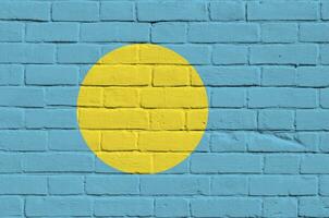 Palau flag depicted in paint colors on old brick wall. Textured banner on big brick wall masonry background photo