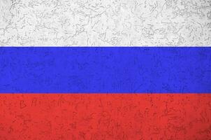 Russia flag depicted in bright paint colors on old relief plastering wall. Textured banner on rough background photo